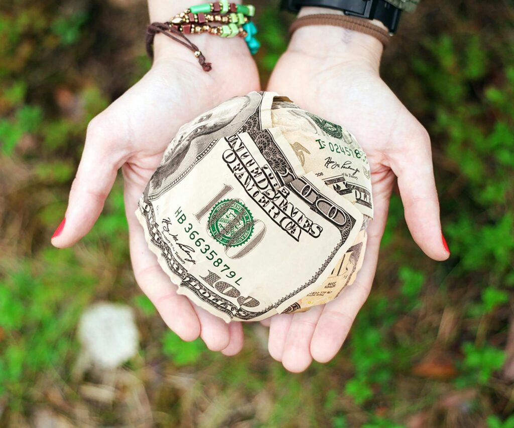 pexels photo 271168 271168 Hands holding crumpled money outdoors, symbolizing charity and financial support.